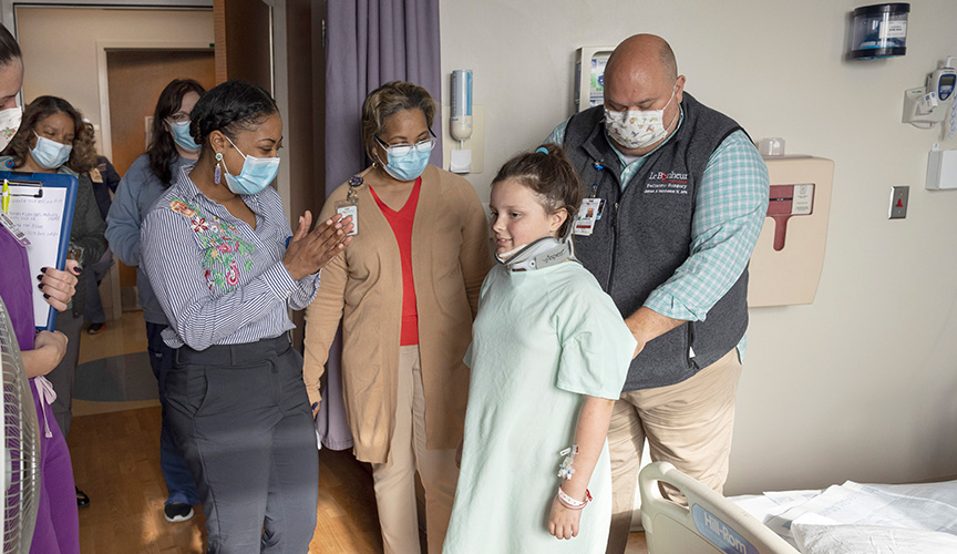 health care providers examine a child with a neck brace.